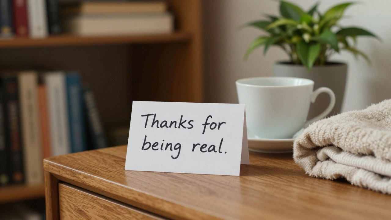 A handwritten note reading &#039;Thanks for being real&#039; beside an empty teacup on a nightstand in a cozy, softly lit room.