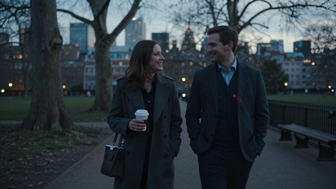 A man and woman walking peacefully side by side in a London park at dusk, laughing gently.