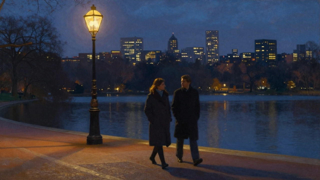 A woman and man walking peacefully along Hyde Park’s lake at night under streetlights.