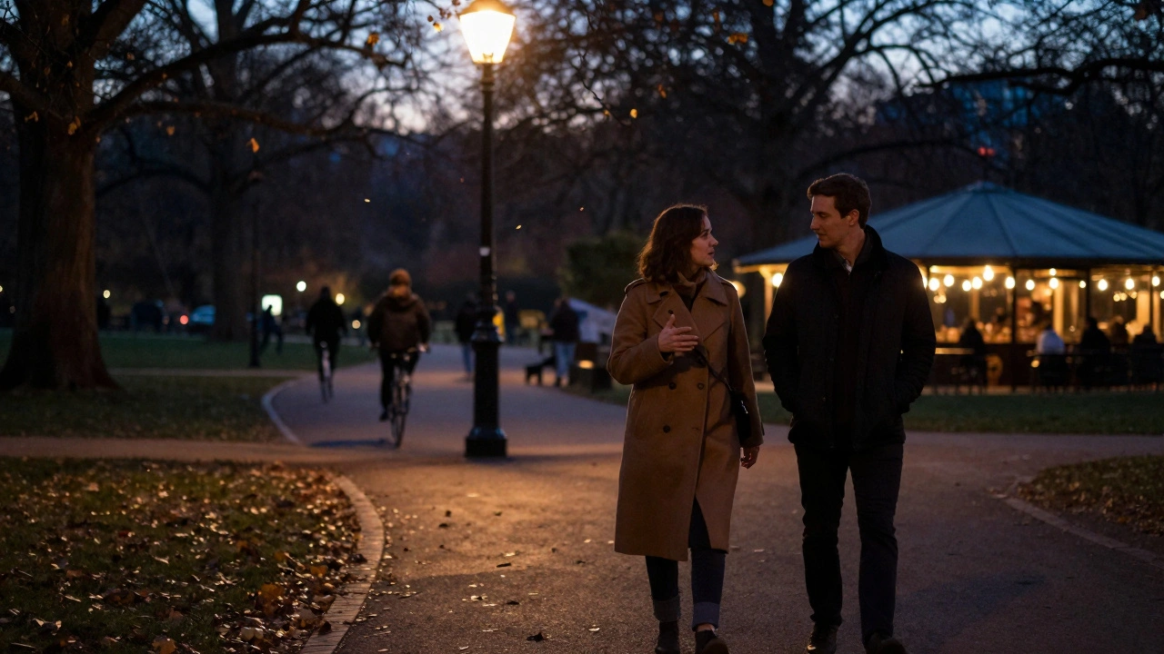 A couple walks peacefully through Hyde Park at twilight under soft streetlamp glow.