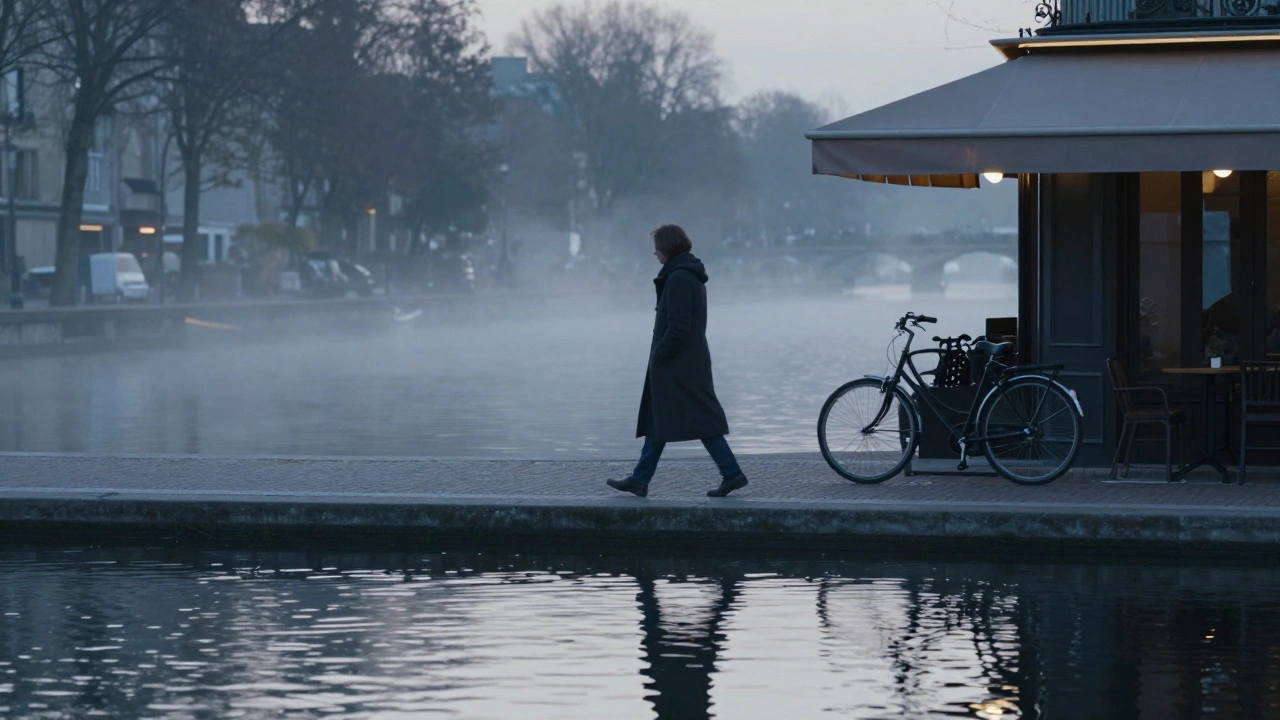 A solitary walker along Canal Saint-Martin at dawn, reflection in the water, mist rising under soft morning light.