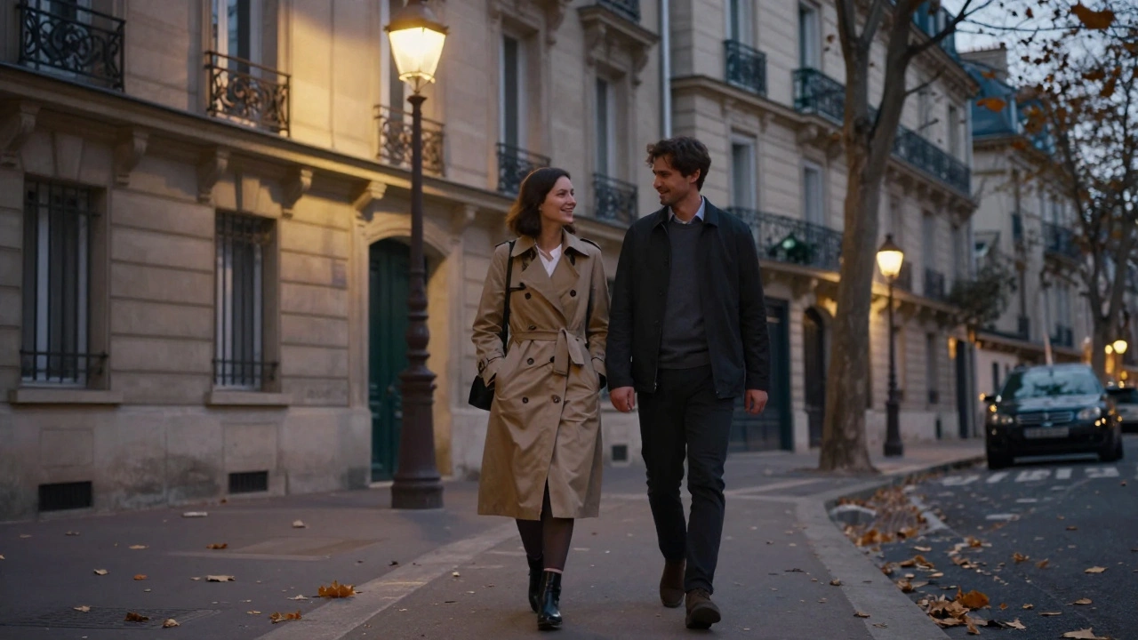 A woman and man stroll along a quiet Paris street at dusk, laughing under golden streetlamps with townhouses in the background.